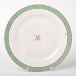 Prato raso em porcelana francesa Séc. XIX, com a letra M ao centro e borda verde, 21 cm de diâmetro.