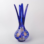 Vaso em vidro na cor azul com decoração floral dourada, terminação com 4 pontas, altura 46 cm.
