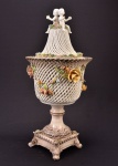 Decorativo potiche com tampa em cerâmica italiana, fenestrada, tampa encimada por 2 Puttis, base quadrada e decorado com flores aplicadas, altura total 59 cm.