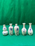 Bonito conjunto de cinco miniaturas de vasos de porcelana branca com desenhos florais azuis. Em bom estado medindo 8 cm de altura.
