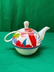 Vintage bule em porcelana esmaltada, decorado com um padrão floral colorido, incluindo flores vermelhas, azuis e laranjas, além de detalhes em verde e azul-escuro. como se encontra nas fotos medindo 10 cm de altura.