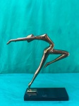 Escultura artística de uma bailarina, estilo arte deco, em metal dourado, sob uma base em mármore negro.Como se encontra nas fotos medindo 26 cm de altura por 18 cm de largura na base