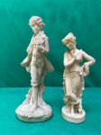Bonito par de esculturas em polímero, representando uma jovem em trajes de época e uma dama em trajes de época. Como se encontra nas fotos, a escultura masculina mede 26 cm de altura e a escultura da dama mede 22 cm de altura.