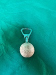 Abridor de garrafas que tem uma bola de golfe acoplada.Como se encontra nas fotos medindo 9 cm de comprimento.    