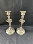 Vintage par de castiçais prateados. Eles possuem um design clássico com uma base larga e redonda, um corpo cônico que se estreita em direção ao topo, e um suporte para vela com formato de disco.Como se encontram nas fotos medindo 28 cm de altura.   