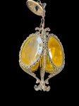 Vintage, bela lâmpada de teto, estilo Art Nouveau, com detalhes ornamentados em bronze. A estrutura principal é oval, com uma lente amarelada que protege a lâmpada interna. O bronze que envolve a lente possui um design intrincado, com padrões florais e curvas elegantes. Na parte inferior, o metal se estende em forma de folhas estilizadas, adicionando um toque decorativo. No estado que se encontra medindo 60 cm de altura.  