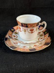England.Bonito conjunto composto por uma xícara de chá, um pires e um prato de sobremesa, em fina porcelana.A decoração apresenta detalhes intrincados e cores vibrantes, incluindo tons de laranja, azul e dourado. A xícara possui uma faixa decorativa na borda superior com desenhos florais e geométricos, enquanto o pires e o prato repetem esses elementos em um layout concêntrico. Detalhes em dourado são usados para contornar as bordas das peças, adicionando um toque de elegância.  Como se encontra nas fotos.  