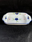 Vintage, a assadeira em fina porcelana A assadeira é retangular, branca, com detalhes florais em azul e amarelo, além de pequenos pontos rosa. A borda da assadeira é contornada por uma linha azul.Em bom estado de conservação, como se encontra nas fotos, medindo 23 cm de comprimento por 12 cm de largura.  