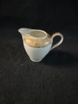HANS.cremeira confecionado em porcelana europeia, na cor off White, decorada com flores e guirlandas, com rico trabalho a ouro.Revisar as fotos atentamente, pois apresenta um pequeno picado. 