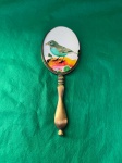 bronze, espelho de mão em bronze, decorado com um passarinho colorido com 20 cm de comprimento.