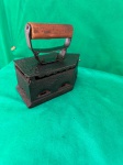 Vintage, ferro de passar roupa antigo a carvão, feito de ferro fundido com um cabo de madeira.