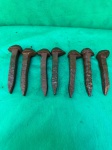 Conjunto de sete pregos de trilho de trem, também conhecidos como "spikes" em inglês, são feitos de aço e usados para fixar os trilhos de trem aos dormentes. A composição do aço utilizado em trilhos e pregos geralmente inclui carbono, manganês e silício, com um teor de carbono controlado para garantir resistência e durabilidade. Como se encontram nas fotos medindo 14 cm de altura