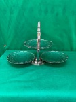 Belíssima fruteira de três andares feito de metal cromado. Ele possui três pratos redondos com bordas decoradas, dispostos em diferentes alturas e conectados por uma haste central que serve como alça.Conforme nas fotos, medindo 40 cm de comprimento, e cada prato mede 18 cm de diâmetro.   
