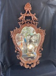 Belíssimo espelho francês de estilo Luís XV em madeira nobre. O espelho possui uma moldura ornamentada em madeira com detalhes esculpidos, incluindo volutas, flores, o espelho apresenta um elevado bisote.  Em bom estado conforme se pode observar nas fotos, medindo 102 cm de altura por 58 cm de largura.    