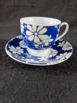 GA.Belíssima xicara de café em fina porcelana, com um design é clássico e elegante, a xícara e o pires apresentam um fundo azul escuro com grandes flores brancas estilizadas.Conforme nas fotos. 