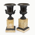Par de ânforas em bronze patinado, com duplas alças, decorados com motivos de folhagens, sobre base