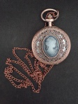 Lindo relógio de bolso vintage em metal rose e ricamente embelezado com figura em relevo de Dama . Acompanha corrente. Funcionando.