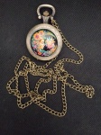 Belo relógio de bolso estilo vintage, em metal bronzeado  e adornado com figura policromada de sol e lua Deusa . Muito criativa. . Funcionando.