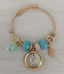 Bracelete dourado , com relógio e berloques na cor azul .