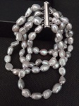 Pulseira com três fios de pérolas de água doce no tom cinza barroco, acabamento na cor prata. Medindo 18 cm de comprimento .