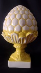 Exuberante pinha com grandes proporções, em cerâmica estilo Santo Antônio do Porto policromada nas cores branca e amarela; medindo 49 cm de altura e a base 18 x 18 cm. A circunferência maior do bojo é de 83 cm. Linda peça. Tem o par no leilão.