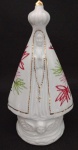 Escultura em porcelana representando Nossa Senhora Aparecida com detalhes à ouro, e detalhes policromados no manto; trabalhada em alto relevo. Medindo 18 cm de altura .