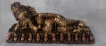 Escultura em resina com patina dourada representando Ganesha em posição de repouso. Medindo 19 x 8 x 4,5 cm.