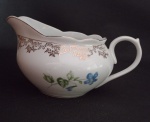 PORCELANA STEATITA - Antiga leiteira em porcelana com decoração floral  e filetagem dourado . Medindo : 17 x 8 x 9 cm .
