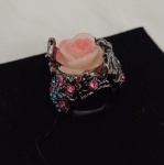 Belo anel decorado com linda flor e pedrinhas nas cores azul e rosa .