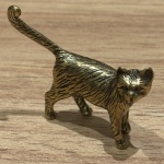 Miniatura representando gato, feito em cobre, rico em detalhes. Medidas: 4 cm x 4,5 cm x 1 cm.