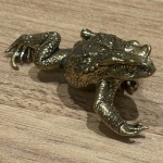 Miniatura representando sapo, feito em cobre, rico em detalhes. Medidas: 2,5 cm x 6 cm x 3 cm.