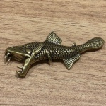 Miniatura representando peixe arowana, feito em cobre, rico em detalhes. Medidas: 3 cm x 8 cm x 0,5 cm.
