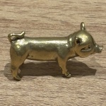 Miniatura representando um porquinho feito em cobre, rico em detalhes. Medidas: 1,5 cm x 3,2 cm x 1cm.
