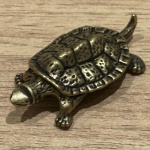 Miniatura representando tartaruga, feito em cobre, rico em detalhes. Medidas: 0,8 cm x 4,5 cm x 2,5 cm.