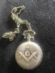 Relógio de bolso com decoração de emblema Maçônico em metal bronzeado . Relógio à quartzo, funcionando.