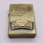 COLECIONISMO - Isqueiro recarregável em metal dourado com figura de uma Ferrari em relevo. Medindo 5,5 x 3,2 x 1,3 cm.
