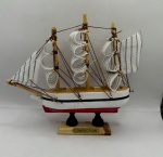 Miniatura de barco decorativo de mesa, feito em madeira, medindo 13 cm de altura, 15 cm de comprimento e  3,5 cm de largura.