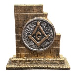 Parede maçônica, em resina, nas cores dourado e prata, medindo 13,5 cm de comprimento, 5 cm de largura e 13 cm de altura. Aproximadamente 300 gramas.
