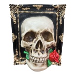 Quadro 3D feito em resina, moldura com fundo preto e detalhes dourados aplicados na borda e crânio com rosa na boca, fixado no centro, criando um efeito tridimensional. Medindo 12 cm de comprimento, 21 cm de largura e 26 cm de altura. Peso aproximado de 1,7 kg.