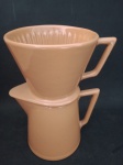 NERINA LOUVEIRA - Antiga cafeteira em louça refratária composta por duas peças , coador e bule , com ornamentação vítrea e esmaltada na cor telha . Medindo : 20 x 15 x 12 cm .