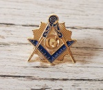 Lindo broche em metal dourado, representando símbolos maçônicos. Medindo 1,9 cm de altura x 1,9 cm de largura. Fechamento de tarraxa.