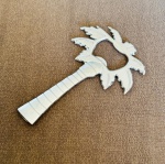 Abridor de garrafa em formato de coqueiro, feito em metal, medindo 10 cm x 7 cm.
