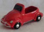 Floreira representando Fusca em faiança na cor vermelha vitrificada. Medindo 27 x 10 x 10 cm.