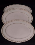 JOHNSON BROS ENGLAND BY - Três Travessas ovaladas em faiança inglesa com marca de sua manufatura em sua base, na cor creme com filetagem dourado .Medindo a maior : 30x24x2 cm.