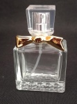 Perfumeiro em vidro translúcido e detalhe em metal dourado, trabalhado em relevo, no interior possui um pequeno palito em vidro para uso do perfume. Medindo 6,5 cm de altura.