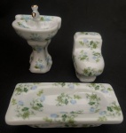 COLECIONISMO - Três miniaturas em porcelana representando peças para banheiro decoradas com rosas. Perfeitas. medindo a banheira 10 x 5 x 3 cm, a pia  10 x 6 x 4.5 cm e o vaso sanitário 7 x 6 x 4 cm.