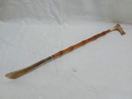 Linda calçadeira em madeira de bambu, pega na forma de cachorro em resina e ponteira de chifre. Medindo 53,5cm de comprimento.