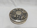 Linda caixa redonda em prata de lei portuguesa com relevos de flores na tampa. Medindo 11cm x 4cm de alltura, pesando 145 gramas.