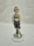 Linda escultura em porcelana alemã Rosenthal, representando menino em trajes típicos. Medindo 16,5cm de altura.