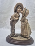 Linda escultura de crianças com trajes típico em resina com base em madeira. Medindo 20cm x 12cm x 26cm de altura. 